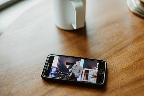 phone on a table with a video of Pastor Mike preaching